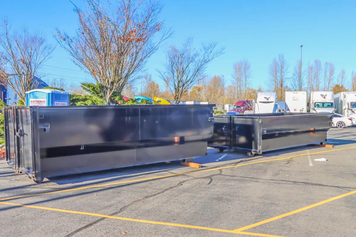 Professional dumpster rental service with roll-off container on residential driveway in East Flat Rock